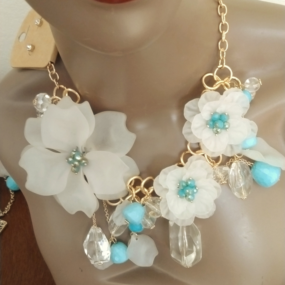 A flower necklace with earrings, gold and turquoise, accents & clear stones